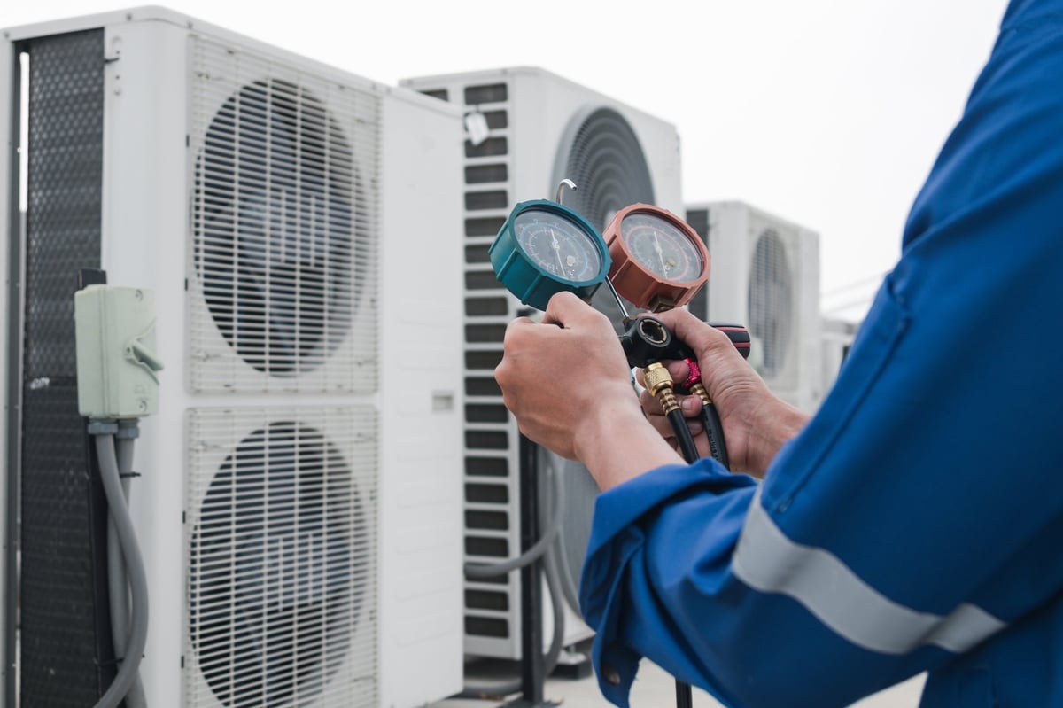 Technician is checking air conditioner, measuring equipment for filling air conditioners.